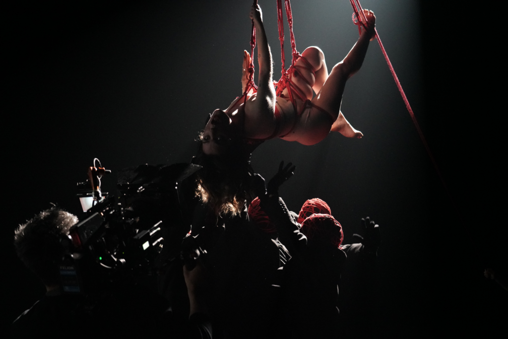 Maeva Nicolas de Bandit Bandit suspendu avec des cordes rouge pour le clip de pyromane