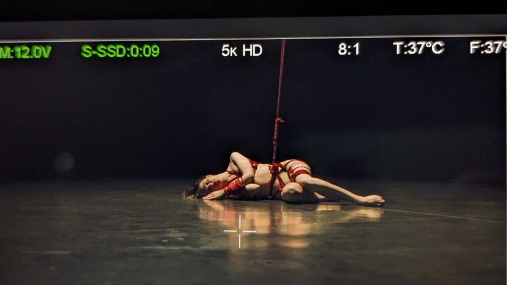 Installation de shibari esthétique avec cordes rouges, réalisée par Lison Vincent pour le clip de bandit bandit